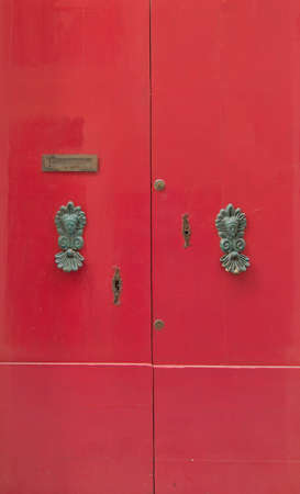 Red door with brass knobs. Painted doors of Malta series.の写真素材