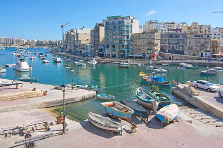 ST JULIANS, MALTA - SEPTEMBER 13, 2015: Small boats moored in St Julians and Spinola bay on a sunny summer day on September 13, 2015 in St Julians, Malta.のeditorial素材
