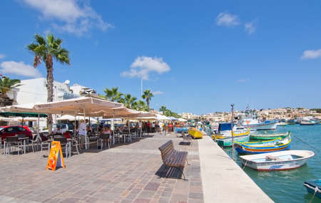 MARSAXLOKK, MALTA - SEPTEMBER 15, 2015: Seaside restaurant on the quay on a sunny day in September 15, 2015 in Marsaxlokk, Malta.のeditorial素材