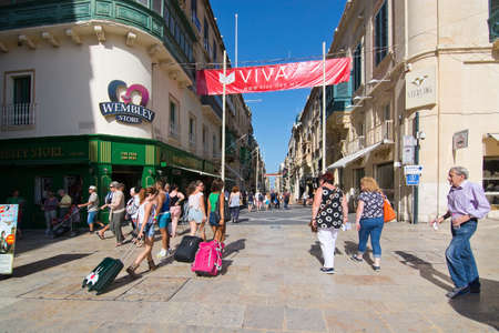 VALLETTA, MALTA - SEPTEMBER 15, 2015: Pedestrians walk in streets of Valletta outside Wembley store on a sunny day in September 15, 2015 in Valletta, Malta.のeditorial素材