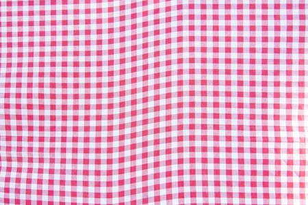 Red and white checkered table cloth fabrics background.の写真素材