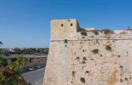 MDINA, MALTA - SEPTEMBER 15, 2015: Outside old city walls and modern parked cars on a sunny day in...