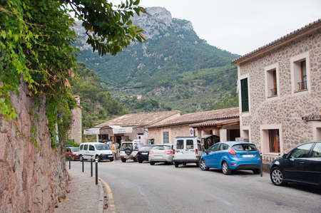 DEIA, MALLORCA, SPAIN - JULY 3, 2011: Cars parked along the main street outside popular food store on an overcast day on July 3, 2011 in Deia, Mallorca, Balearic islands, Spain.のeditorial素材