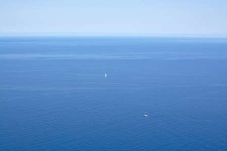 Blue Mediterranean seascape with two boats in the distance in Mallorca, Balearic islands, Spain in July.の写真素材