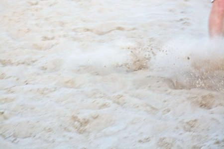 Beach soccer leg closeup with soft sand speed cloud