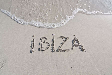 Ibiza written in sand on beach with wave in Ibiza, Balearic islands, Spainの写真素材