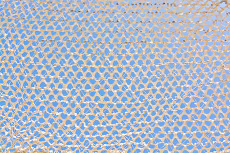 Sunshade white background with hole pattern full frame and blue sky.