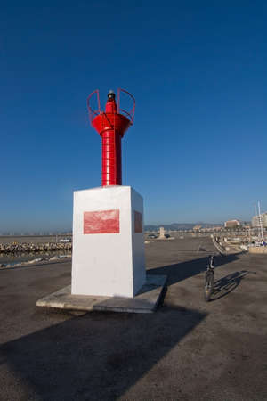 PALMA DE MALLORCA, BALEARIC ISLANDS, SPAIN - DECEMBER 22, 2015: Small red lighthouse in Portixol and parked bike on a sunny day on December 22, 2015 in Palma de Mallorca, Balearic islands, Spainのeditorial素材
