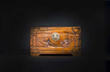 Chinese wooden box on dark background.