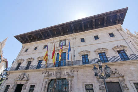 PALMA DE MALLORCA, BALEARIC ISLANDS, SPAIN - APRIL 13, 2016: City hall in Plaza Cort with balcony and flags in Palma de Mallorca, Balearic islands, Spain on April 13, 2016.のeditorial素材
