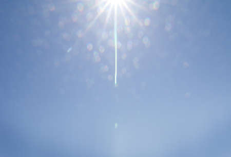 Sun shining from blue sky light effects background.