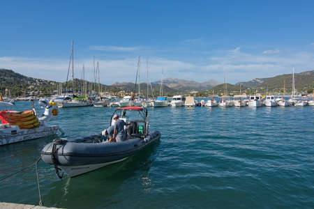 PORT ANDRATX, MALLORCA, SPAIN - AUGUST 5, 2016: Two men onboard a rib boat in port on a sunny summer day in August 5 in Port Andratx, Mallorca, Spain.のeditorial素材