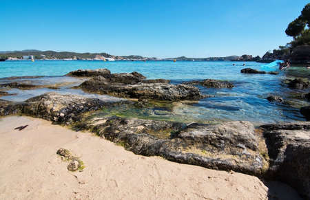 CALA FORNELLS, MALLORCA, SPAIN - SEPTEMBER 6, 2016: Green water beach, bathers and boats on a sunny day on September 6, 2016 in Cala Fornells, Mallorca, Spain.のeditorial素材