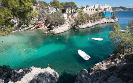 CALA FORNELLS, MALLORCA, SPAIN - SEPTEMBER 6, 2016: Green water beach, bathers and boats on a sunny day on September 6, 2016 in Cala Fornells, Mallorca, Spain.のeditorial素材