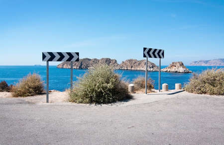 Warning traffic sign near steep cliff by islets of Malgrats on a sunny summer day in Santa Ponsa,...
