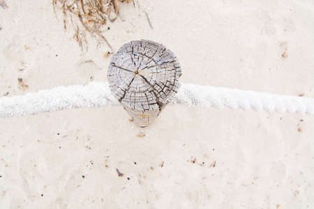 Beach wood pole rope fence and sandy feet in Formentera, Balearic islands, Spain.の写真素材