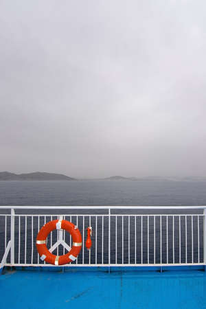 Orange life ring on ferry crossing on an overcast day on October 25, 2016 at sea between Palma and...