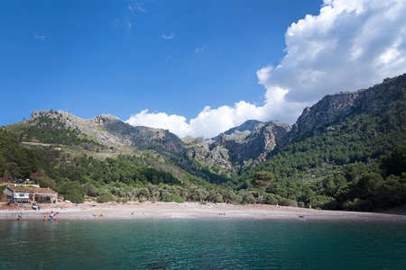 CALA TUENT, MALLORCA, SPAIN - MAY 15, 2017: Beach kiosque and beach with few tourists on May 15, 2017 in Cala Tuent, Mallorca, Spain.のeditorial素材