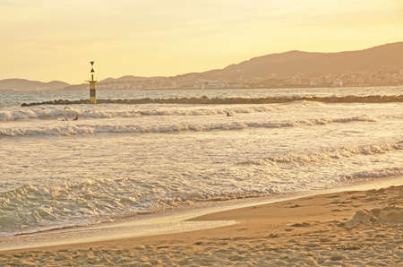 PALMA DE MALLORCA, BALEARIC ISLANDS, SPAIN - JUNE 29, 2017: Surfers at Molinar beach on a sunny and windy summer evening on June 29, 2017 in Palma de Mallorca, Balearic islands, Spain.のeditorial素材