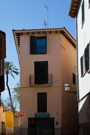 PALMA DE MALLORCA, BALEARIC ISLANDS, SPAIN - MARCH 29, 2017: Two three story buildings and blue sky...