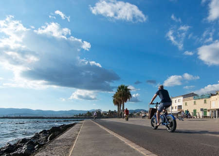 PORTIXOL, MALLORCA, BALEARIC ISLANDS, SPAIN - SEPTEMBER 27, 2017: People out and about along the promenade on a sunny day on September 27, 2017 in Portixol, Mallorca, Balearic islands, Spain.のeditorial素材