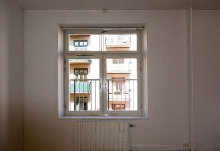 White room shabby interior with window view on typical 1900 building in Stockholm, Sweden.の写真素材