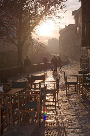 GRANADA, ANDALUCIA, SPAIN - DECEMBER 20, 2017: Outdoor cafe chairs in Bar Fontana on the Carrera del Darro in afternoon sunhaze on December 20, 2017 in Granada, Andalucia, Spainのeditorial素材