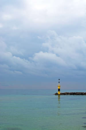 Pier lighthouse horizon. Tranquility on Mediterranean winter beach in Mallorca, Balearic islands, Spain in February.の写真素材