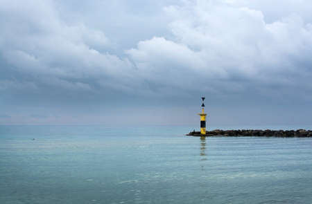 Pier lighthouse horizon. Tranquility on Mediterranean winter beach in Mallorca, Balearic islands, Spain in February.の写真素材