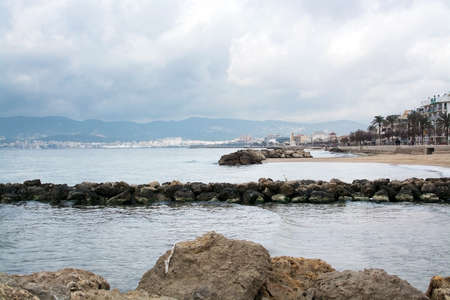 PALMA DE MALLORCA, SPAIN - FEBRUARY 1, 2018: Palma de Mallorca view with city in light and cathedral and white pelikan in foreground on winter beach on February 1, 2018 in Mallorca, Balearic islands, Spain.のeditorial素材