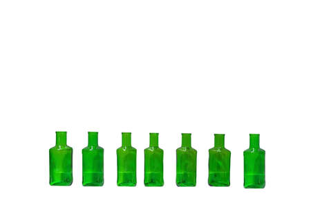 Green glass bottles lined up in a row isolated on white backgroundの写真素材