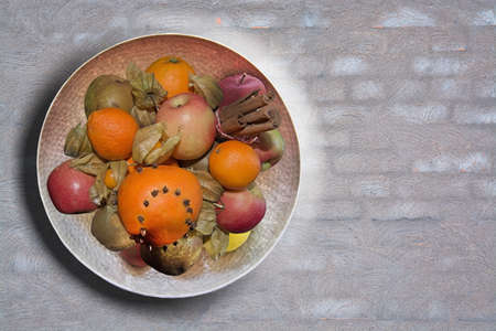 Fruit bowl on grey washed brick wall background texture for copy spaceの写真素材