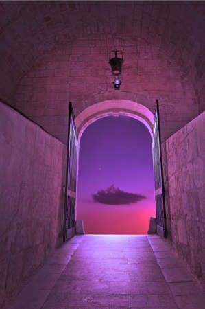 Purple cloud on pink sky with small star, through the gates of medieval fairy tale gates - concept for new dimensions, transition, dream, wishing or hope concept.の写真素材