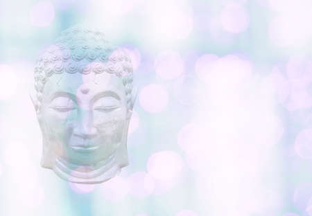 Buddha head on bokeh lights soft pink green pastel color background bokeh textureの写真素材