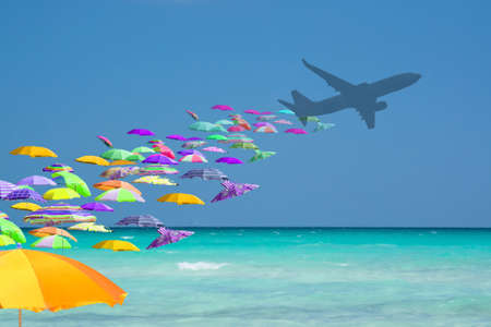Colorful parasols tourist invasion from airplane turquoise water in tourist paradise travel playful mass tourism concept.の写真素材