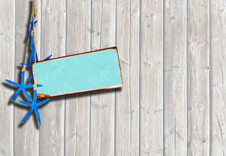 Boardwalk planks background with blue starfish and turquoise metal plate for copy spaceの写真素材