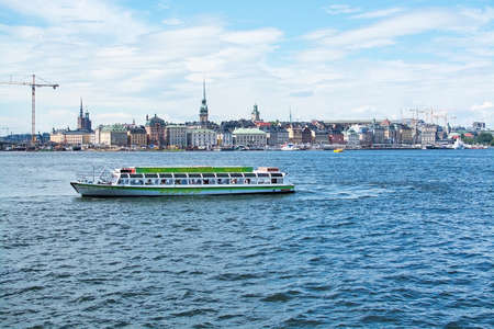 STOCKHOLM, SWEDEN - JULY 11, 2018: Boats for sightseeing and ferry for long distance travel in front of Stockholm skyline at Stadsgardskajen on July 11, 2018 in Stockholm, Sweden.のeditorial素材