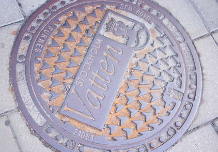 STOCKHOLM, SWEDEN - JULY 11, 2018: Manhole lid with Stockholm signage in iron on July 11, 2018 in Stockholm, Sweden.のeditorial素材