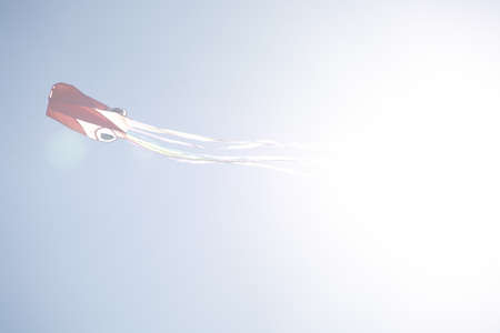 Red kite flying high against blue sky in Mallorca, Spain.