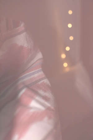 Vertical closeup of traditional Majorca red ikat fabric and bokeh light string toned in Living Coral...