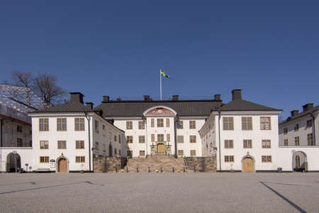 STOCKHOLM, SWEDEN - APRIL 20, 2019: Karlberg castle front with Swedish flag on a sunny day on April 20, 2019 in Stockholm, Sweden.のeditorial素材