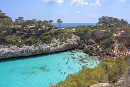 CALO DES MORO, MALLORCA, SPAIN - JULY 27, 2019: Small extremely turquoise bay and steep cliffs on a...