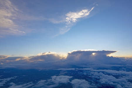 Dreamy aerial cloud landscape flying high above the Earth with thunderclouds on a sunny day.