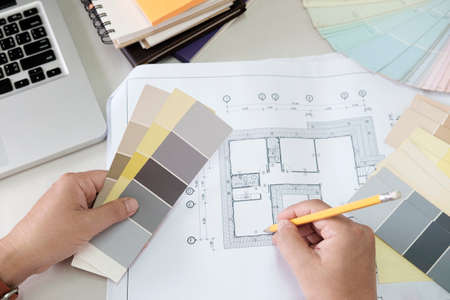 Graphic design and color swatches and pens on a desk. Architectural drawing with work tools and...