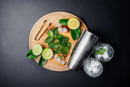 Mojito cocktail making. Mint, lime, lemon, ice ingredients and bar utensils. Top view. Copy space.の写真素材