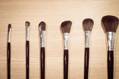 Vintage looking professional makeup brushes on wood backgroundの写真素材