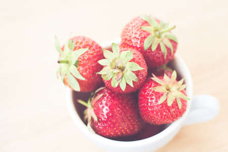 Cup of retro looking vibrant delicious strawberriesの写真素材