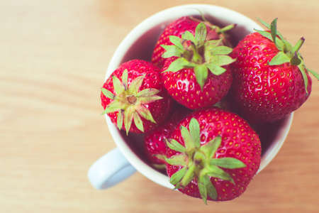 Cup of retro looking vibrant delicious strawberriesの写真素材