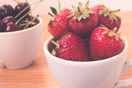 Cup of retro looking vibrant delicious strawberriesの写真素材