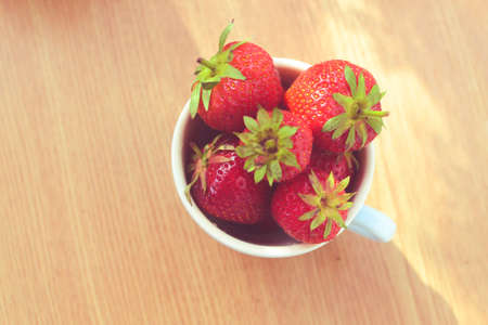 Cup of retro looking vibrant delicious strawberriesの写真素材